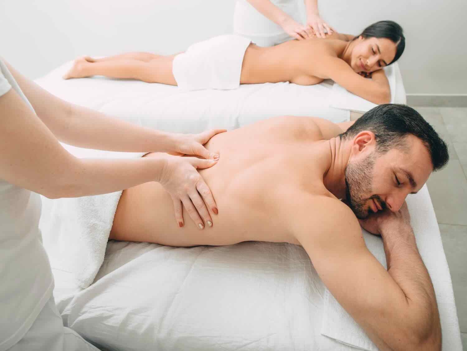 Beautiful couple getting a back massage, weekend spa for couple. Beautiful mixed race woman and man relaxes while back massage