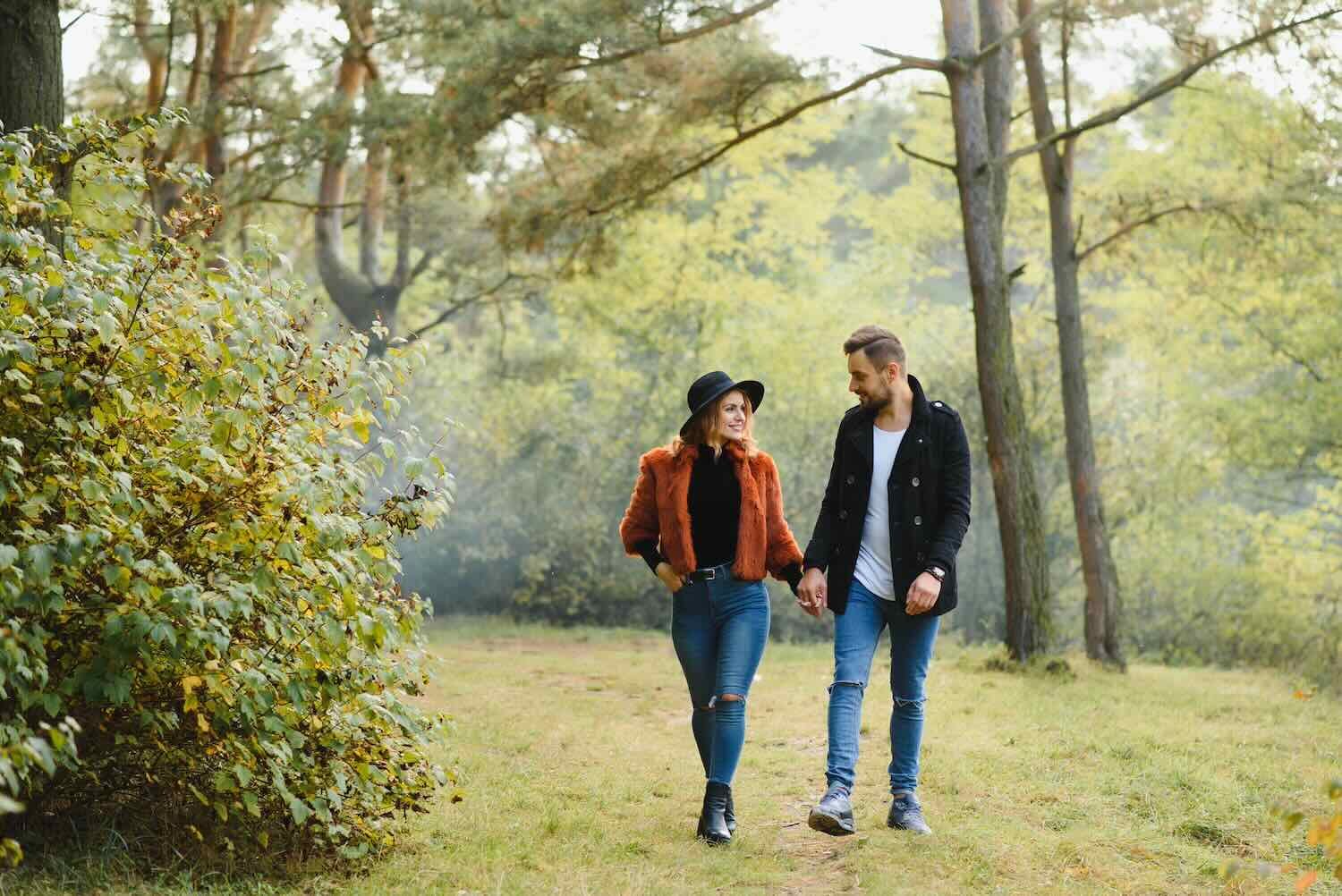 Lovers walking hand in hand in autumn park